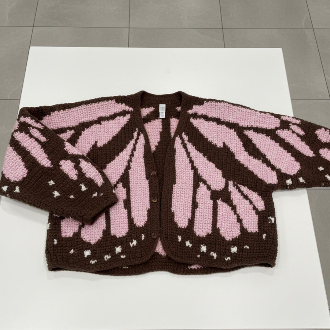 crocheted cardigan with monarch butterfly pattern on a white surface