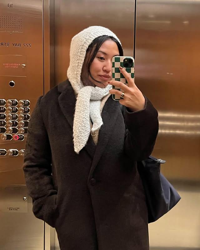 Elegant woman modeling the Crocheted hooded scarf – soft handmade hood for cold days.