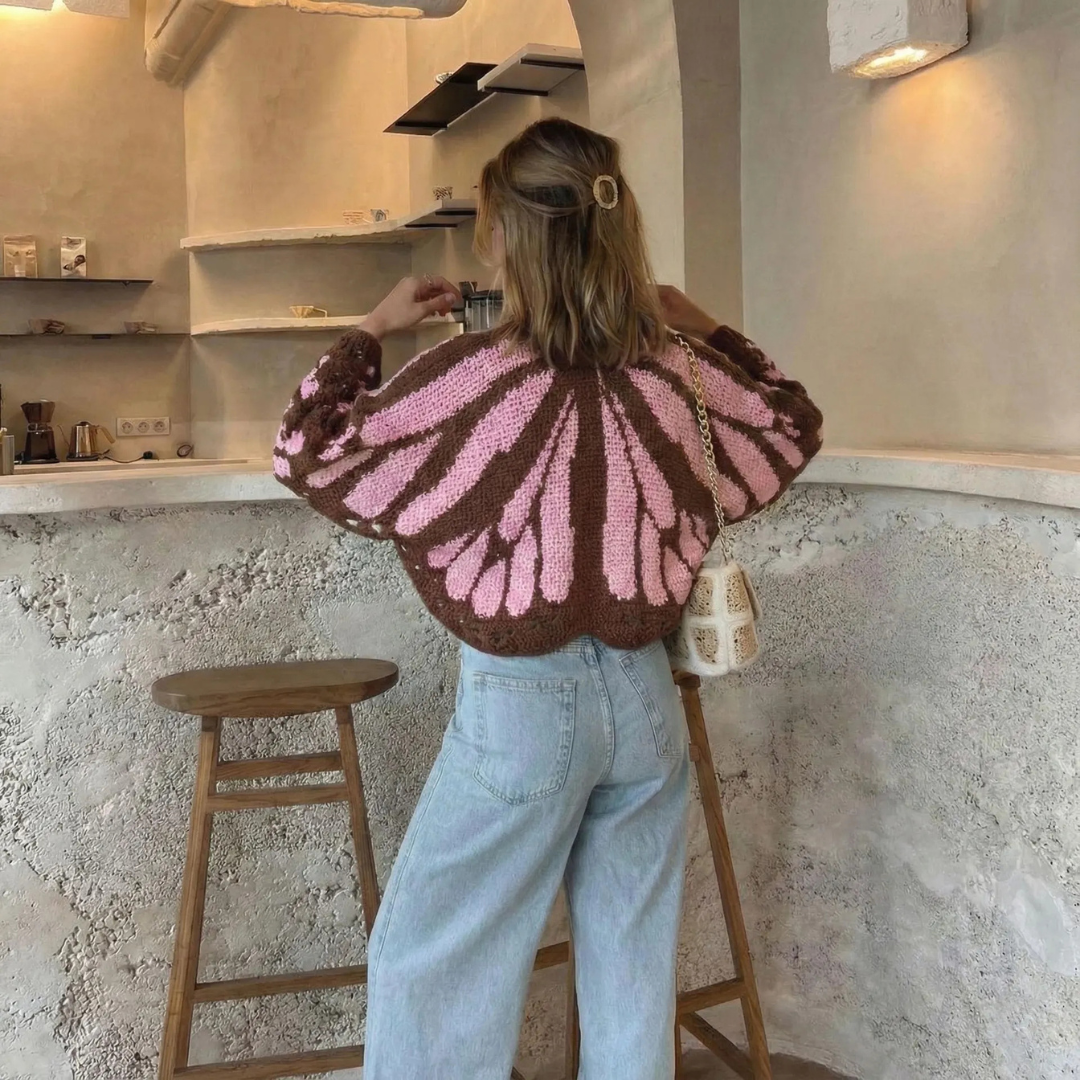Person wearing a monarch butterfly-patterned cardigan in a kitchen