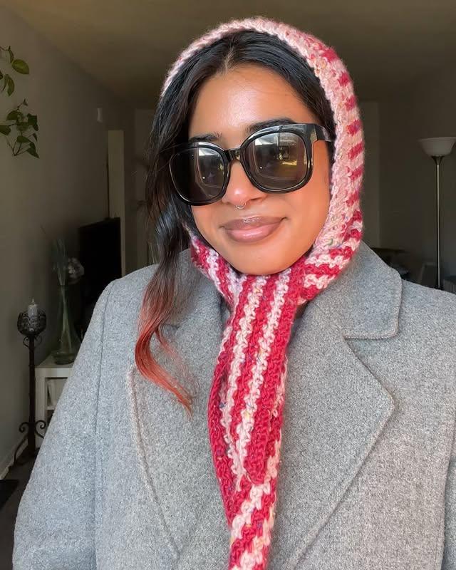 Woman smiling while wearing Crochet hooded scarf – cozy winter handmade outfit.